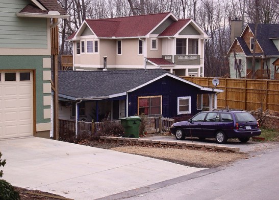 Are those McMansions bringing down the little house's value? (Photo by zen Sutherland, Creative Commons)