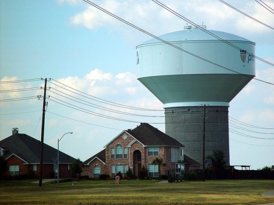 photo of a new tract house with an immense water tower in background